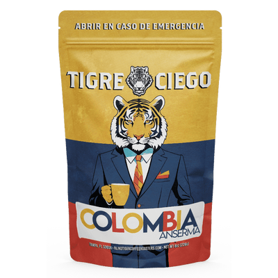 Coffee bag with a tiger illustration wearing a suit and holding a coffee cup, featuring the brand 'Tigre Ciego' and 'Colombia Anserma'.
