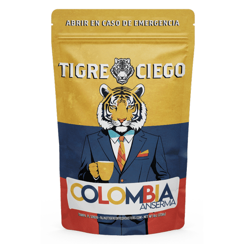 Coffee bag with a tiger illustration wearing a suit and holding a coffee cup, featuring the brand 'Tigre Ciego' and 'Colombia Anserma'.
