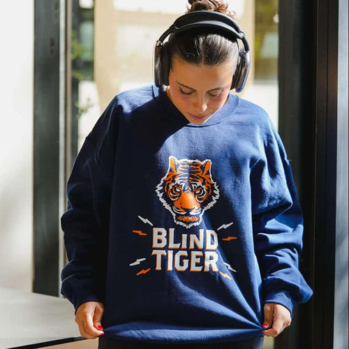 Person wearing a blue sweatshirt with a tiger graphic and 'Blind Tiger' text.