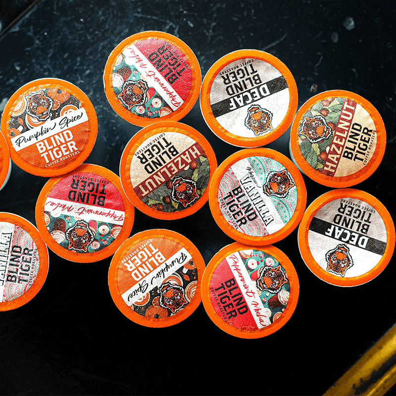 Collection of Blind Tiger coffee pods on a dark surface