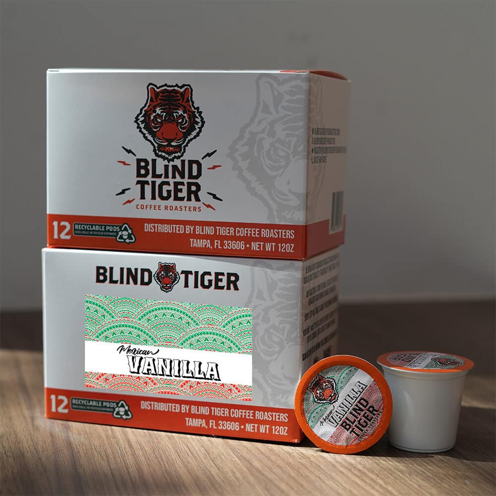 Blind Tiger coffee pods and packaging on a wooden surface with a neutral background