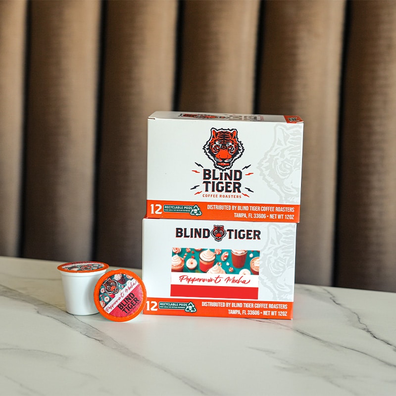 Box of Blind Tiger coffee pods on a marble surface with a neutral background