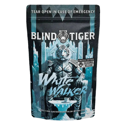 A bag a coffee with a white tiger sitting on a throne of ice with a coffee cup. 